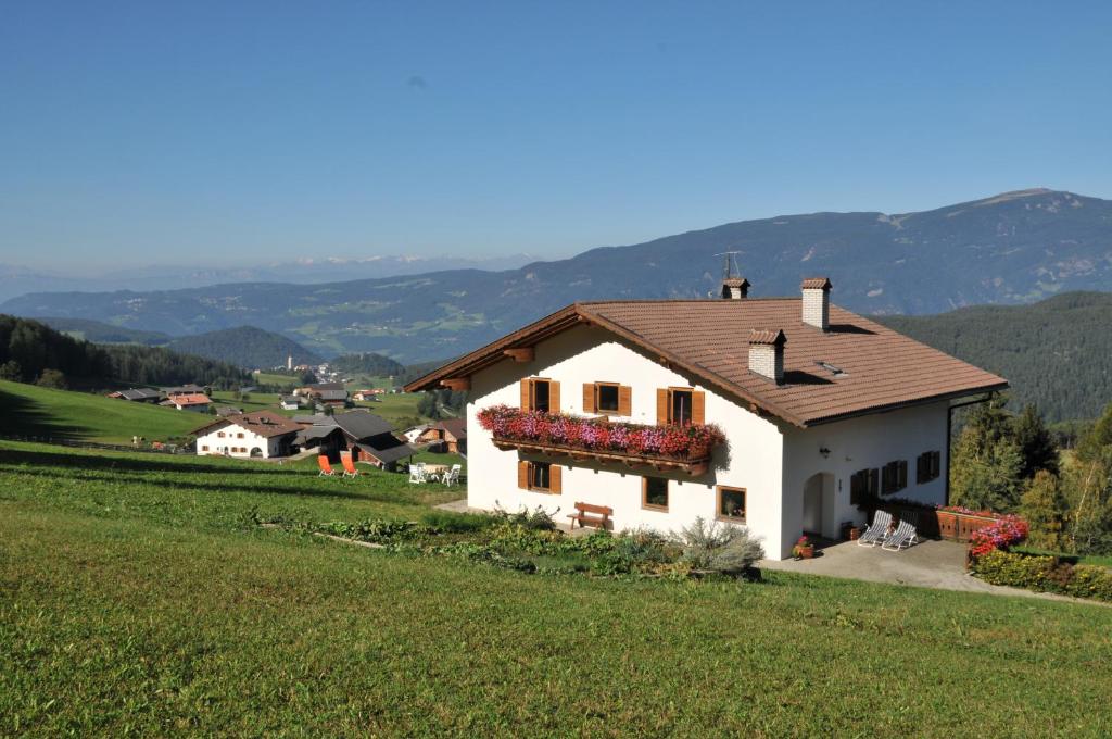 una casa blanca en una colina en un campo en Fiziderhof, en Castelrotto