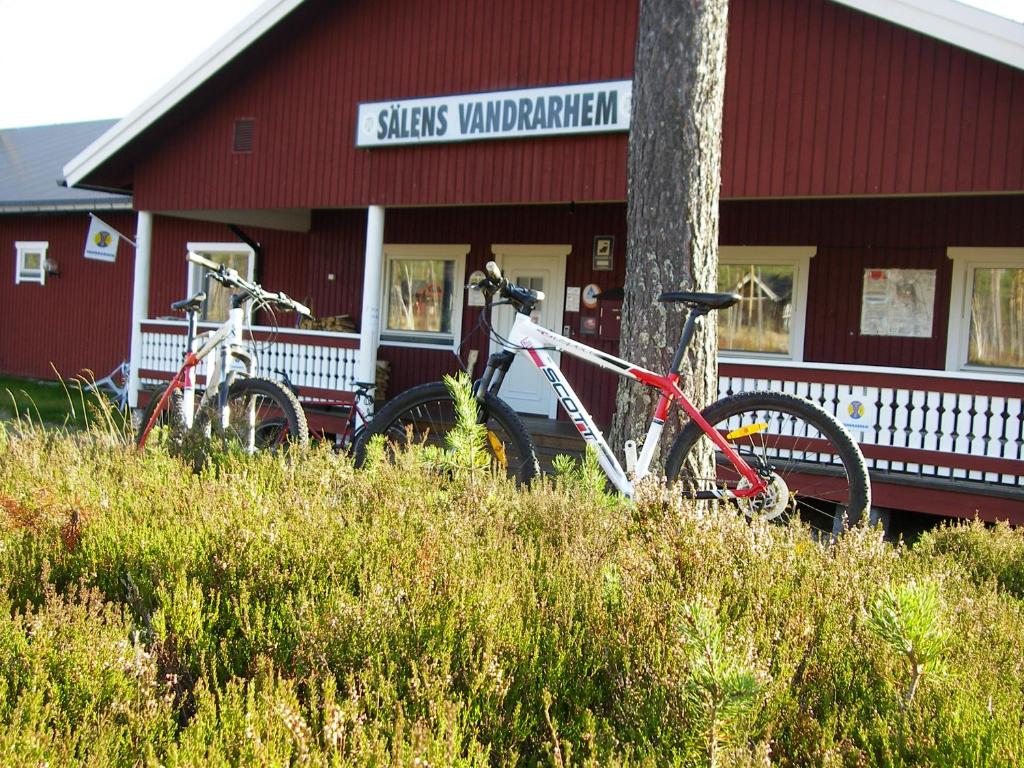 dwa rowery zaparkowane przed czerwonym budynkiem w obiekcie STF Vandrarhem Sälen w mieście Stöten