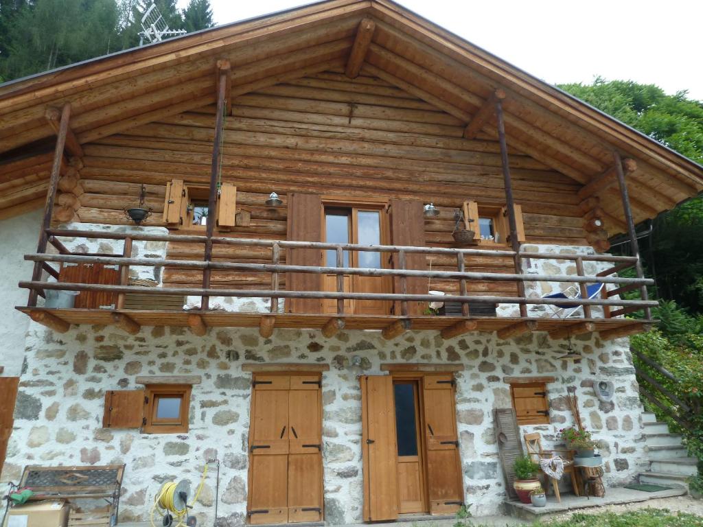 una baita di tronchi con balcone sopra di Il Ciliegio a Imer