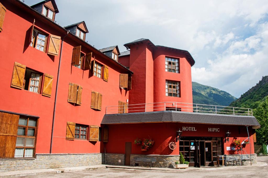 a red building with a balcony on top of it at Hotel Hipic in Vielha
