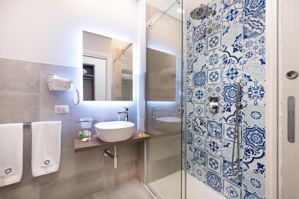a bathroom with a sink and a shower at Hermes Hotel in San Vito lo Capo