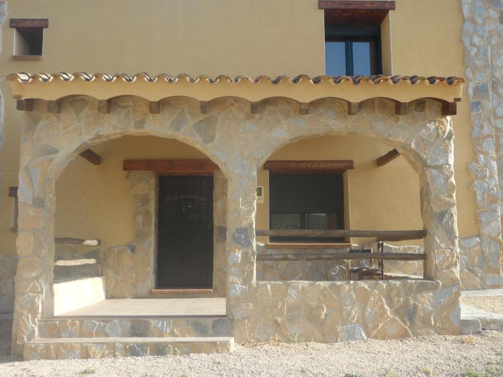 an outdoor patio with two arches on a building at Casa la Peña in Alpera