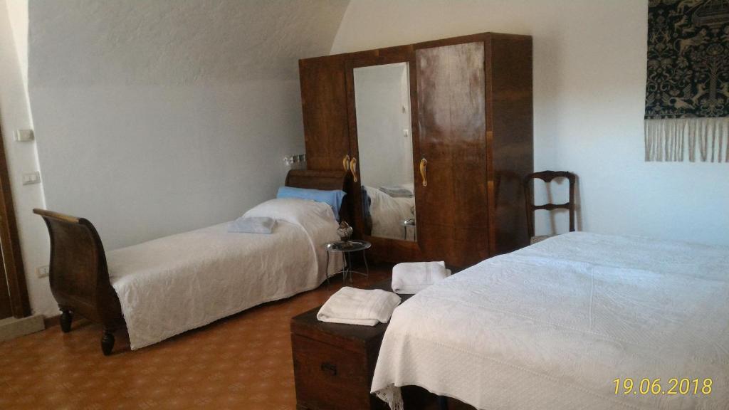 a hotel room with two beds and a chair at Agriturismo Holle in Manerba del Garda
