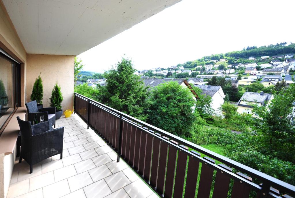 einen Balkon mit Stühlen und Stadtblick in der Unterkunft Im Kirchberg in Lieser