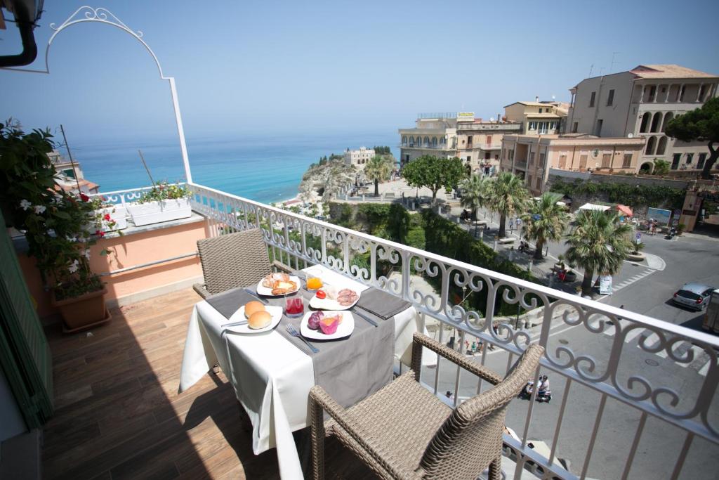una mesa con comida en el balcón con vistas al océano en Il Duca en Tropea
