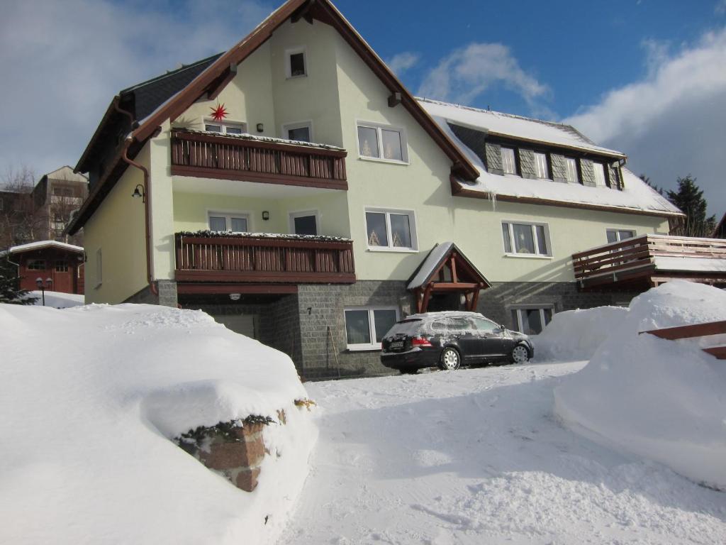 una casa con mucha nieve delante de ella en Ferienwohnungen Oberwiesenthal, en Kurort Oberwiesenthal