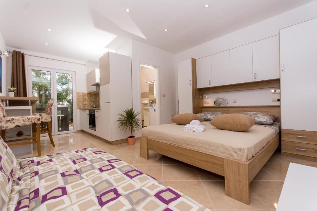 a bedroom with a large bed and a kitchen at Apartment Sandra in Trogir