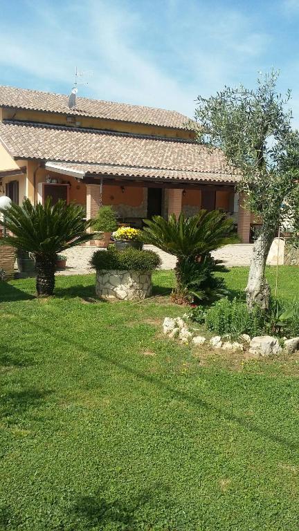 a house with a yard with green grass and trees at Casale Del Borgo in Hermada