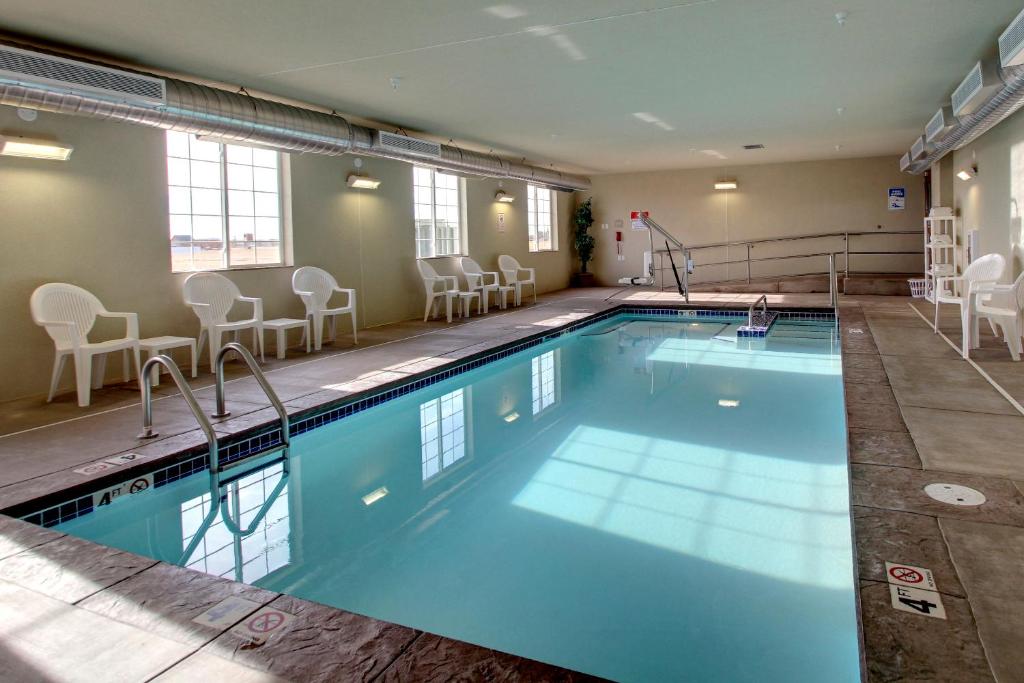 uma grande piscina interior com cadeiras e mesas num edifício em Cobblestone Hotel - Wayne em Wayne