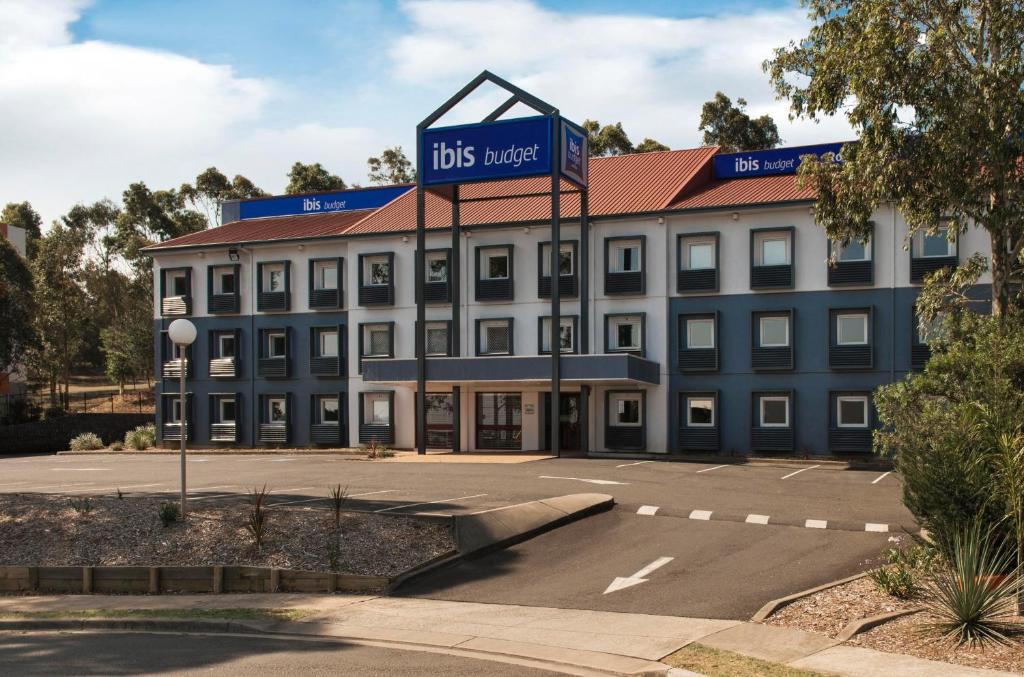 a large building with a sign on top of it at ibis Budget - Campbelltown in Campbelltown