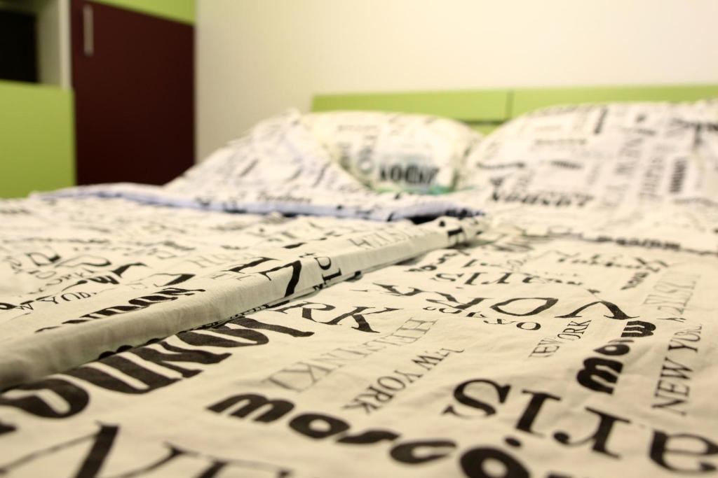 a bed with a comforter with writing on it at Green Bear in Sarajevo