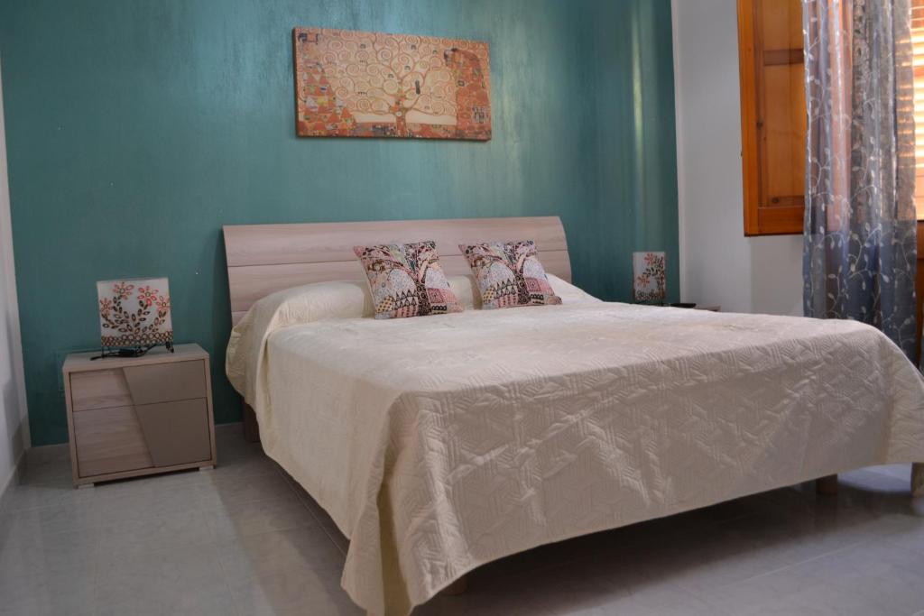 een slaapkamer met een bed met een groene muur bij Al Madinah in Mazara del Vallo