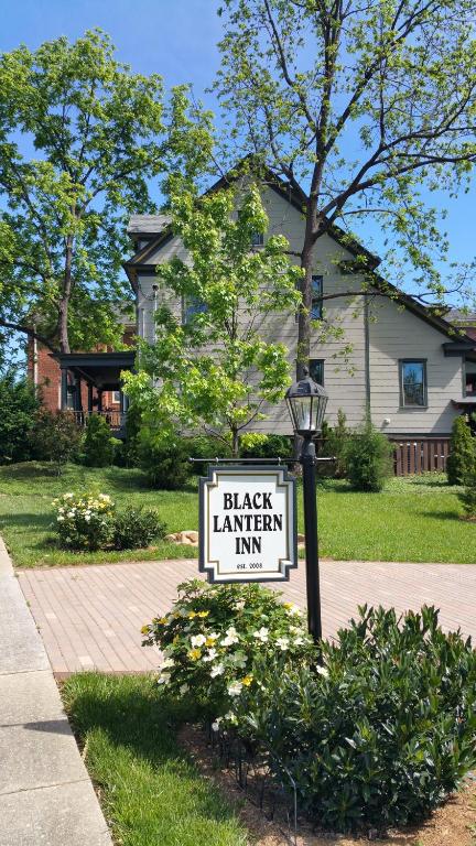 una señal para una taberna negra frente a una casa en Black Lantern Inn en Roanoke