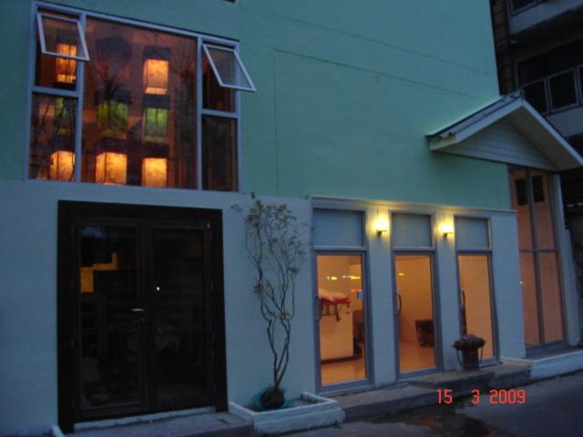 un edificio con ventanas y una puerta delante de él en Kaset Guesthouse, en Bangkok