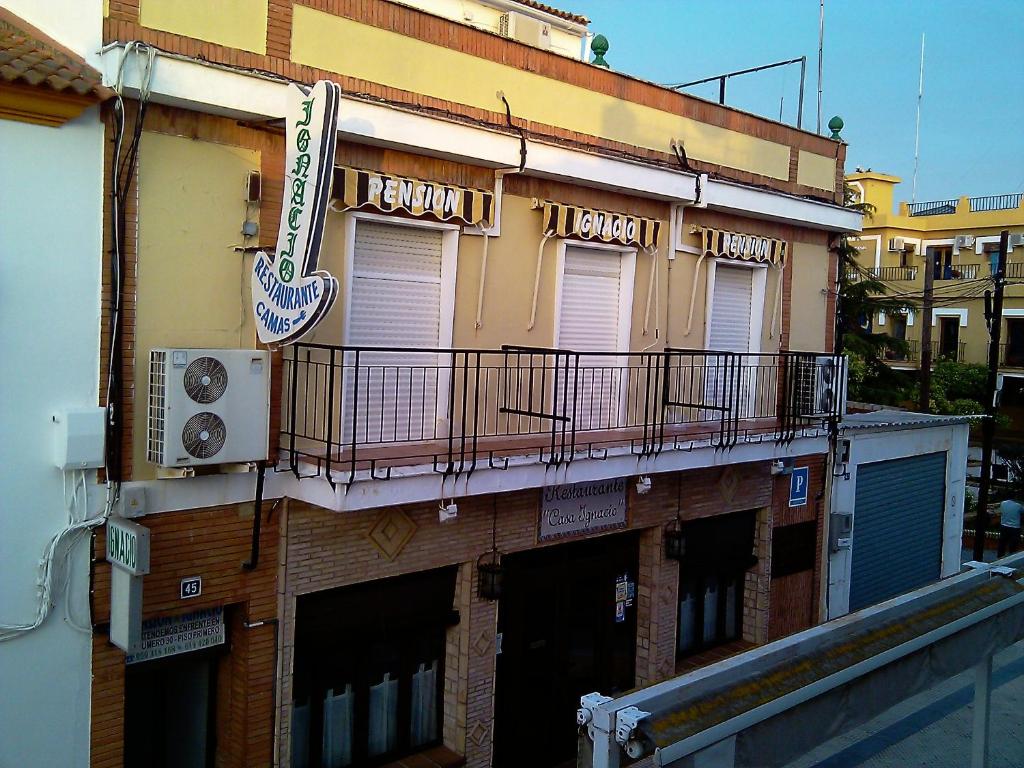 un edificio con un balcón en el lateral. en Pensión Ignacio, en Aljaraque