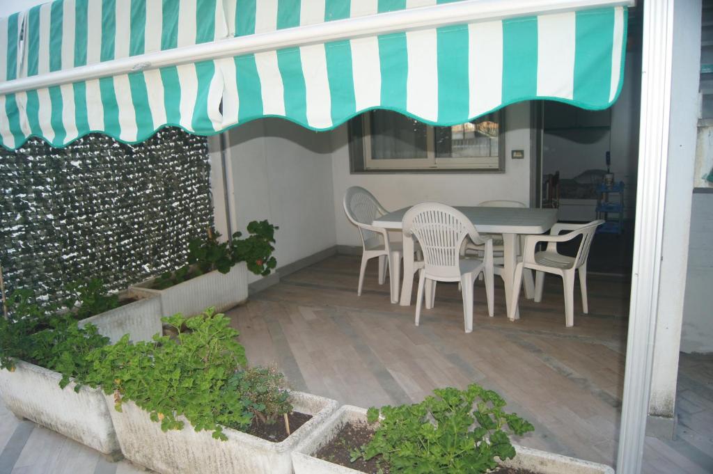 een patio met een tafel en stoelen onder een luifel bij Residence On The Beach in Vasto