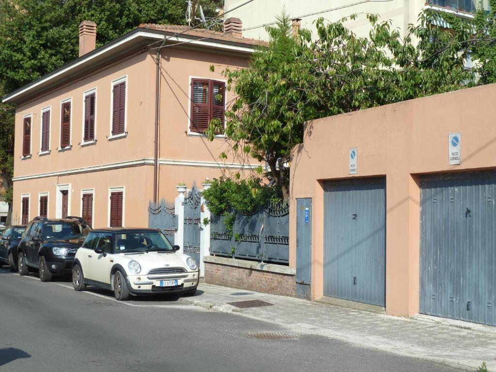 une voiture blanche garée dans une rue à côté d'un bâtiment dans l'établissement Ginko, à Pesaro