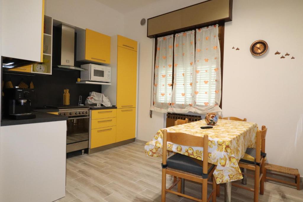 eine Küche mit einem Tisch und eine Küche mit gelben Schränken in der Unterkunft Am Liv' (mi alzo) in Bologna