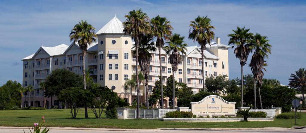 a large white building with palm trees in front of it at Monumental Hotel Orlando in Orlando