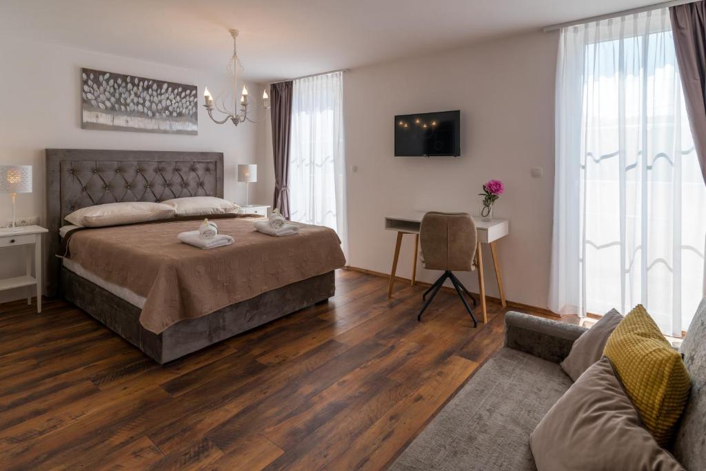 sypialnia z łóżkiem, biurkiem i kanapą w obiekcie SOBE "GALEB" w mieście Vrbnik
