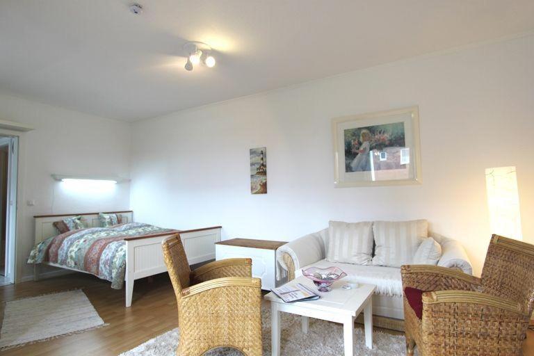 ein Wohnzimmer mit Sofa und Bett in der Unterkunft Moin Moin in Hörnum