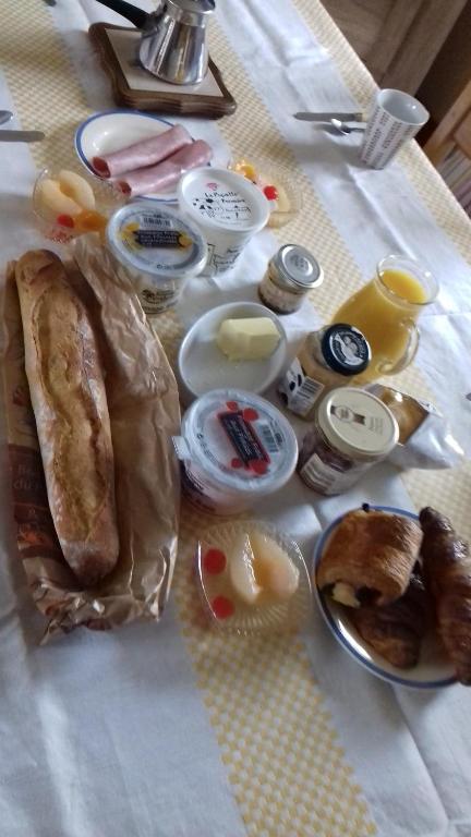 a table with a bag of bread and other food at Chambres d'Hotes Elvire et Laurent Barbey in Sainte-Marie-du-Mont
