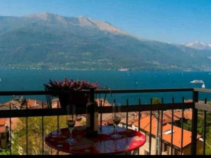 una mesa en un balcón con vistas al agua en House Carla en Bellano