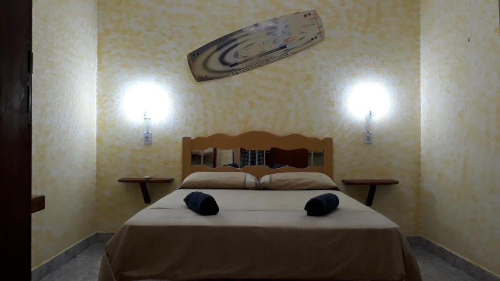 1 dormitorio con 1 cama grande y 2 luces en la pared en Kite House Jeri, en Jericoacoara