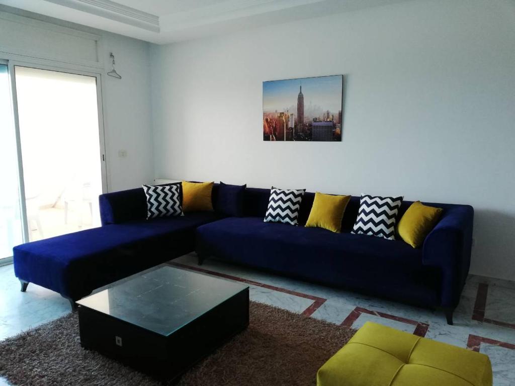 a living room with a blue couch with yellow pillows at Appartement Lac 2 in Berges Du Lac
