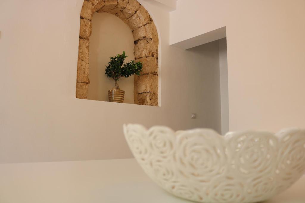 un tazón blanco sentado en un mostrador con un espejo en Casa vacanze Cortile Barocco, en Noto
