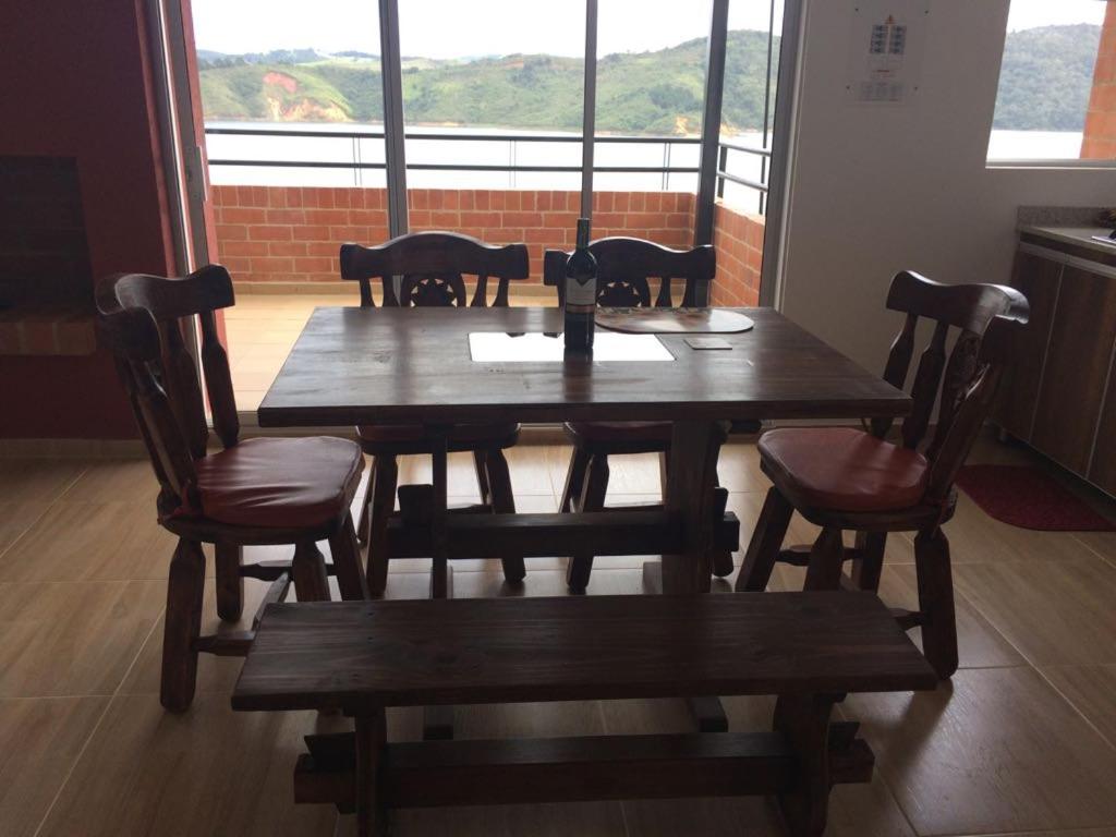 mesa de madera y sillas con mesa y ventana en Majagua Villa Campestre, en Calima