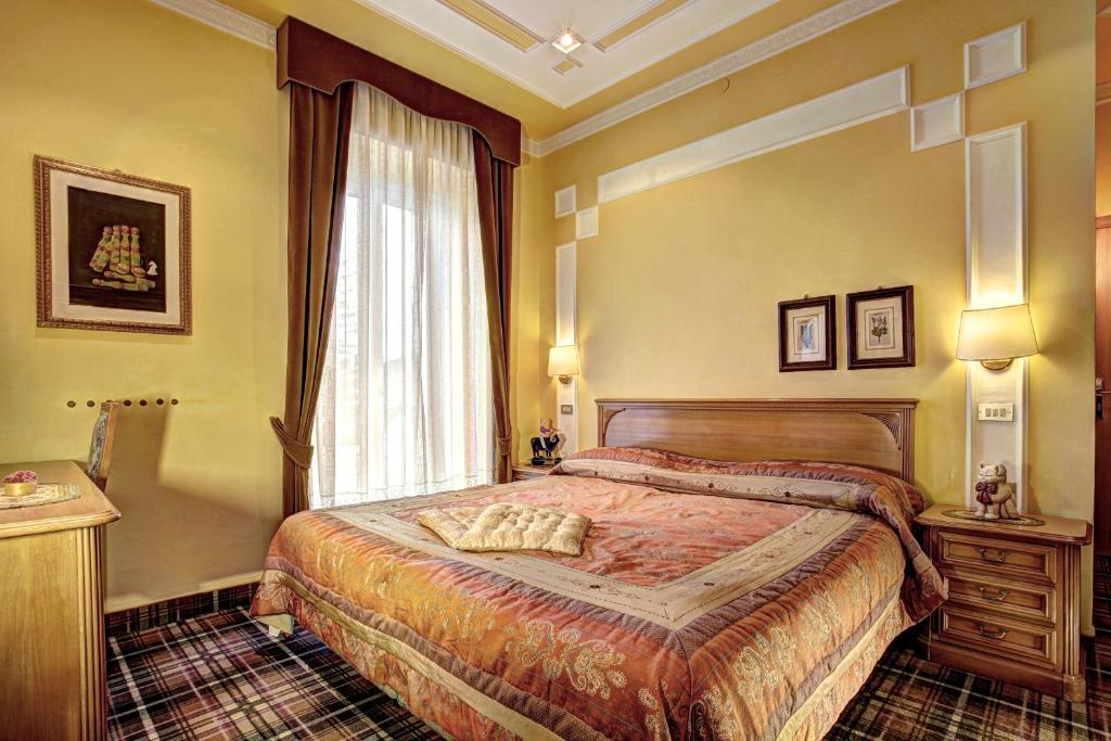a bedroom with a bed and a window at Hotel Regina in San Martino di Castrozza