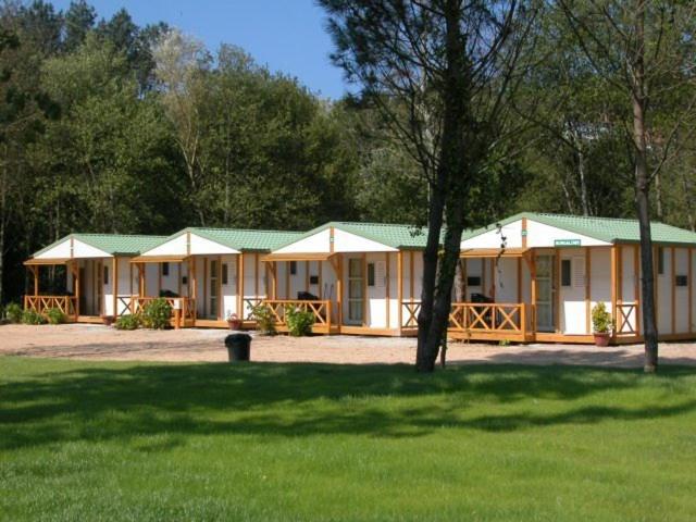 una casa con techo verde en un parque en Camping Baltar en Portonovo
