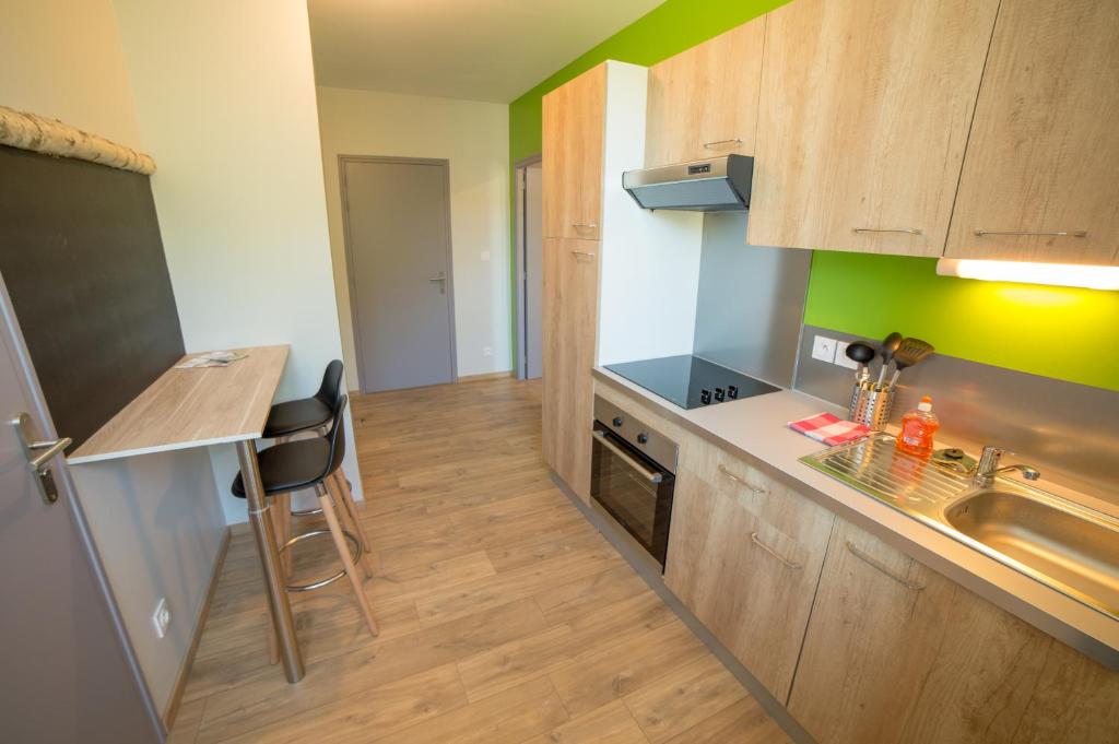uma pequena cozinha com um lavatório e um fogão em Appart Hotel de la Souleuvre em Le Bény-Bocage