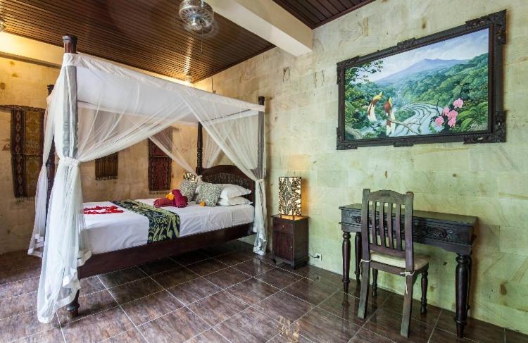 een slaapkamer met een hemelbed en een bureau bij Rumah Kelinci in Ubud