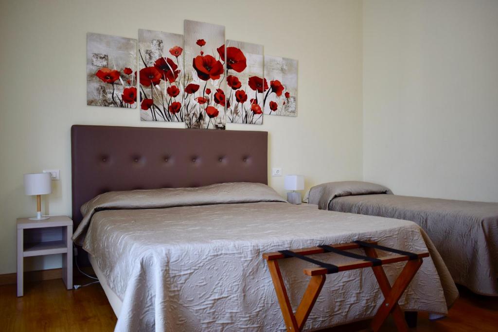 ガルダにあるLa Lanternaのベッドルーム1室(赤い花の壁にベッド1台付)