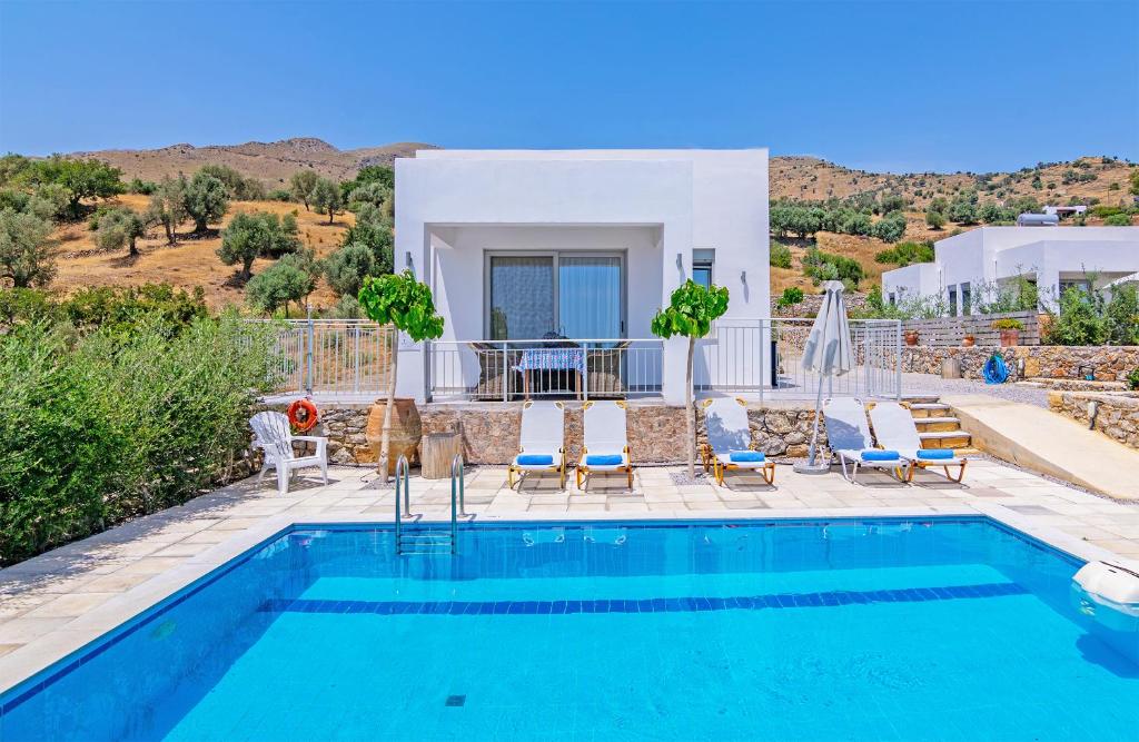 een villa met een zwembad en een huis bij Evgoro Luxury Suites in Agia Galini