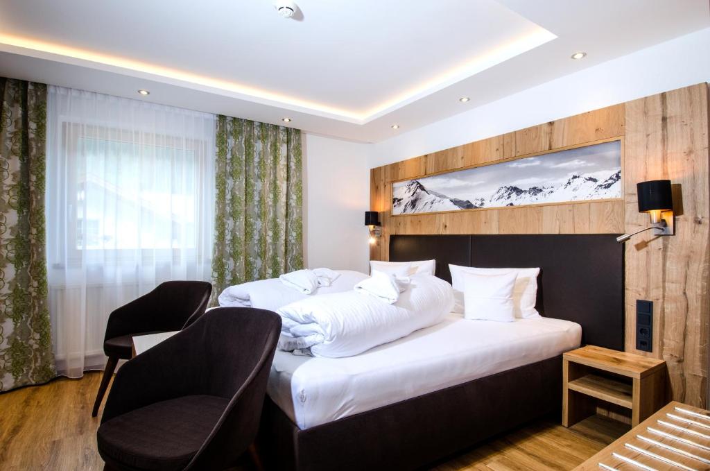 Postel nebo postele na pokoji v ubytování Hotel Garni Siegele - inklusive Silvretta-Card PREMIUM