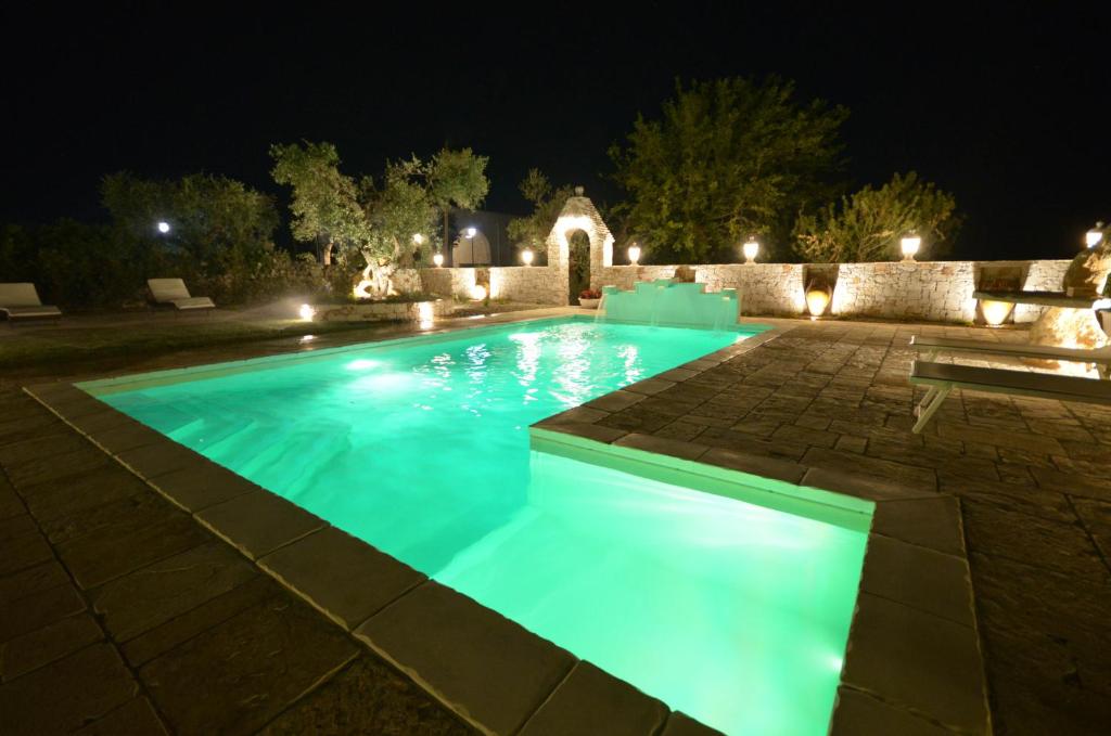 Villa Petra Chiara في لوكوروتوندو: حمام سباحة مع أضواء زرقاء في الفناء في الليل