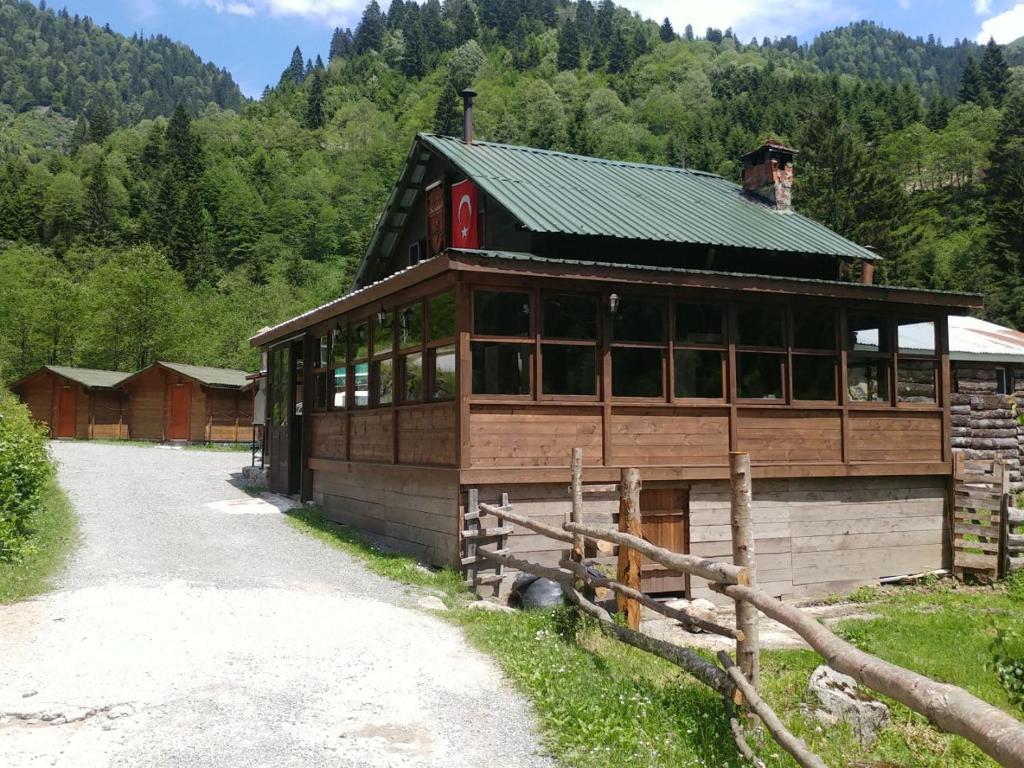 ein großes Holzgebäude mit grünem Dach in der Unterkunft Kardelen Bungalov Evleri̇ in Ayder Yaylasi