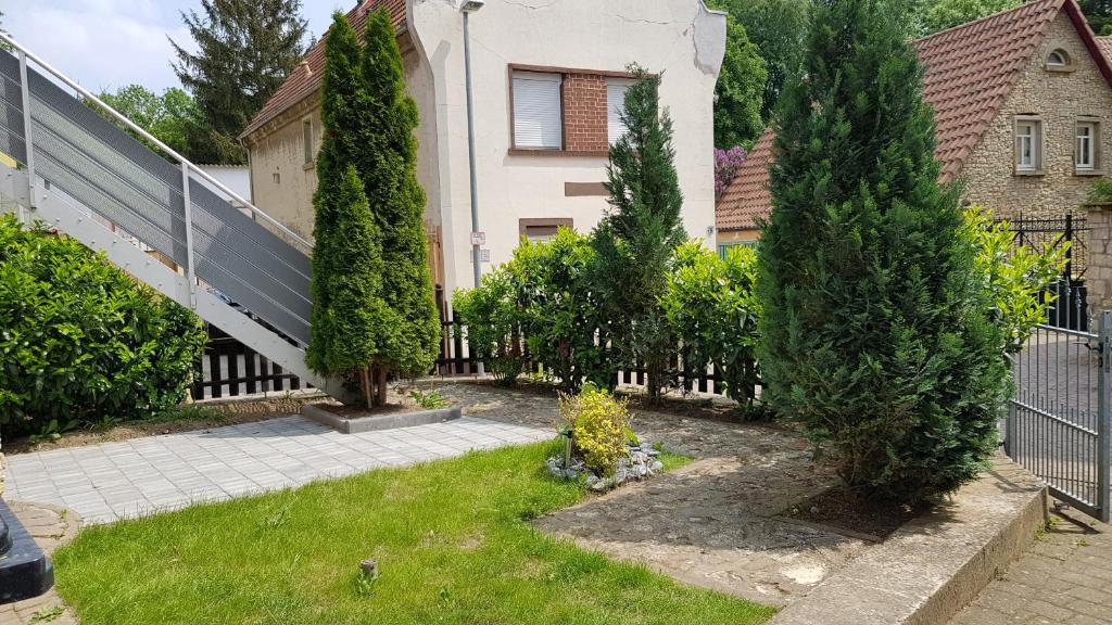 a garden in front of a house with trees and a fence at Ferienwohnung in Freimersheim