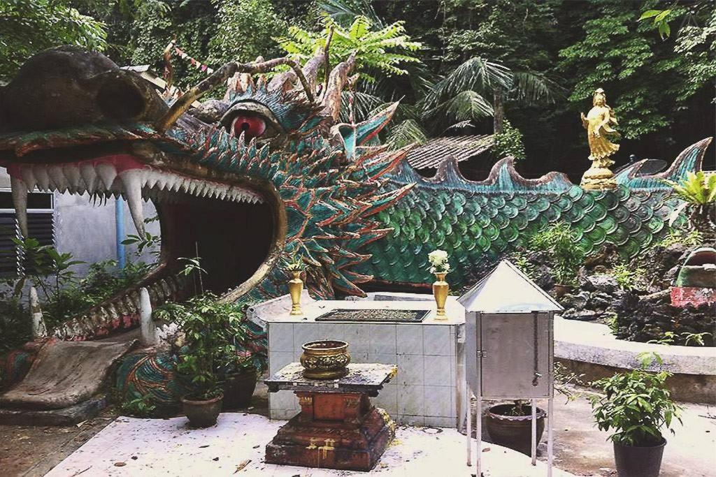 a statue of a dragon in a garden at Thai Muang Resort in Thai Muang