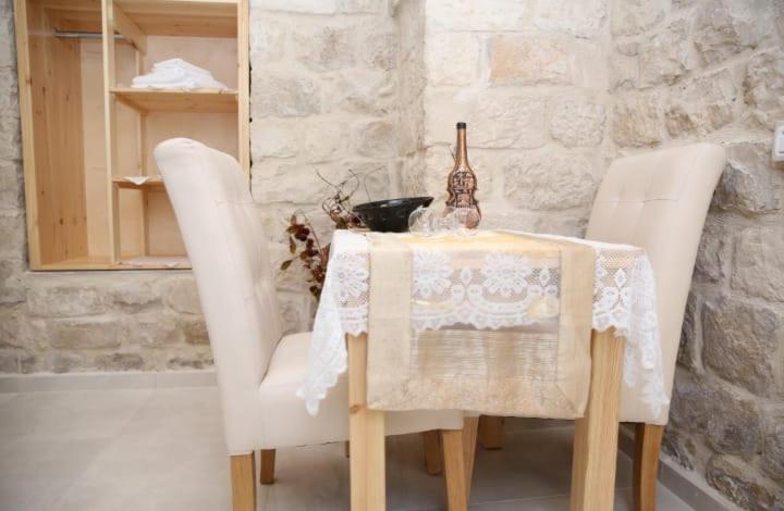 a table with two white chairs and a white table cloth at Mendy's Accommodation in Safed