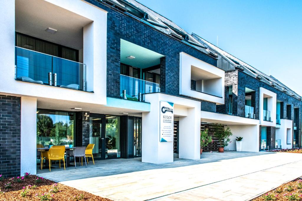 a building with a table and chairs in front of it at Open Hotel Szentes in Szentes
