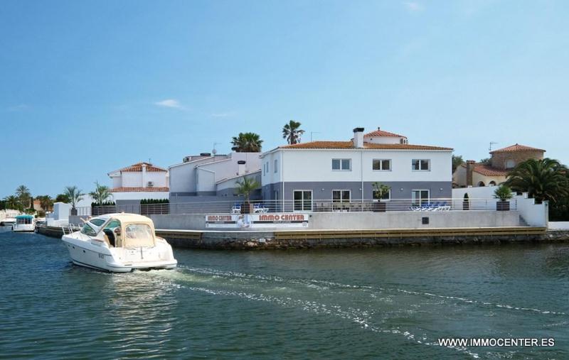 een witte boot in het water naast een huis bij LV04 in Empuriabrava