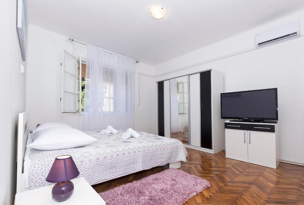 um quarto com uma cama e uma televisão de ecrã plano em Apartment Mario em Split