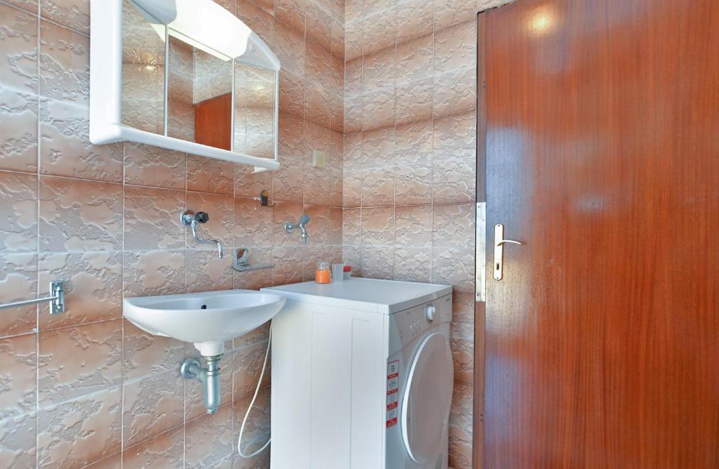 łazienka z białą umywalką i lustrem w obiekcie Apartments Gracijano 1724 w mieście Ližnjan