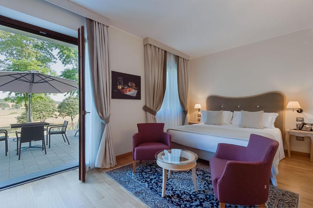 Borgo La Chiaracia Resort & SPA في Castel Giorgio: غرفة نوم بسرير وفناء مع طاولة