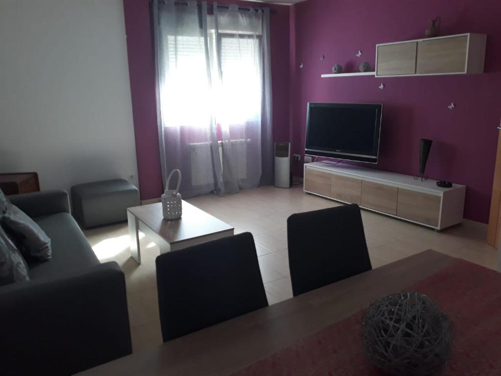 a living room with a couch and a tv at Manzanares in Manzanares