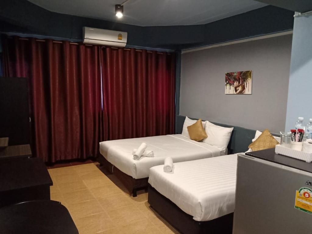 una camera d'albergo con due letti e una tenda rossa di M Place a Ban Kao